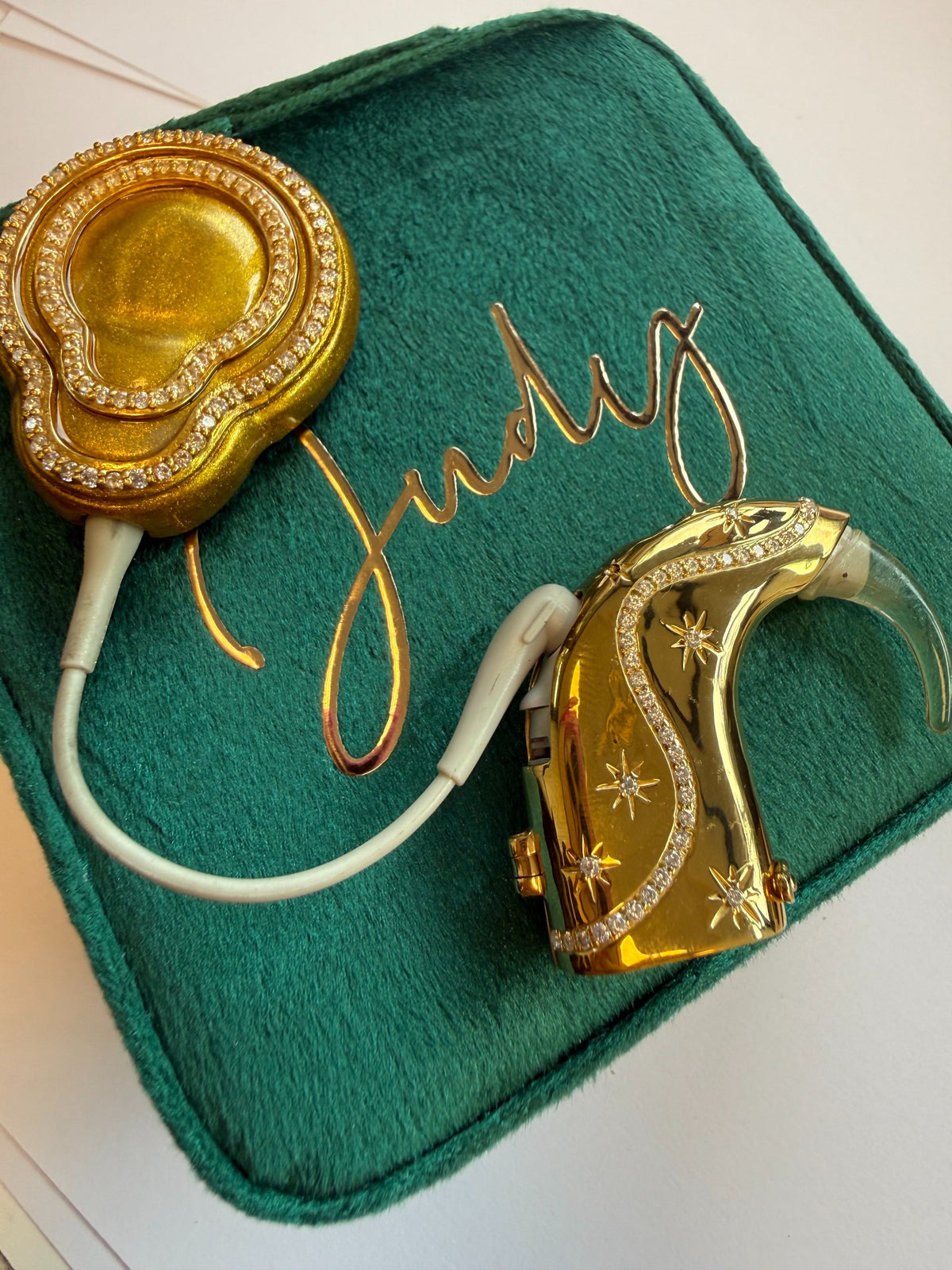 Afterglow cochlear implant jewellery in gold on green velvet