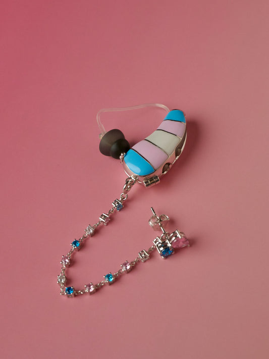Trans Pride hearing aid cover and coordinating chain on pink background