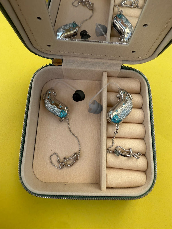 Bethan's bespoke silver and turquoise Auzi hearing aid covers displayed in their jewellery case