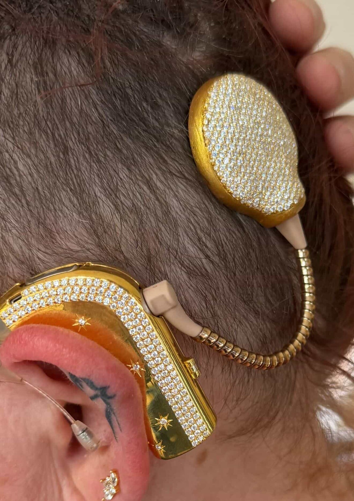 Shine Bright cochlear jewellery worn in yellow gold with white stones